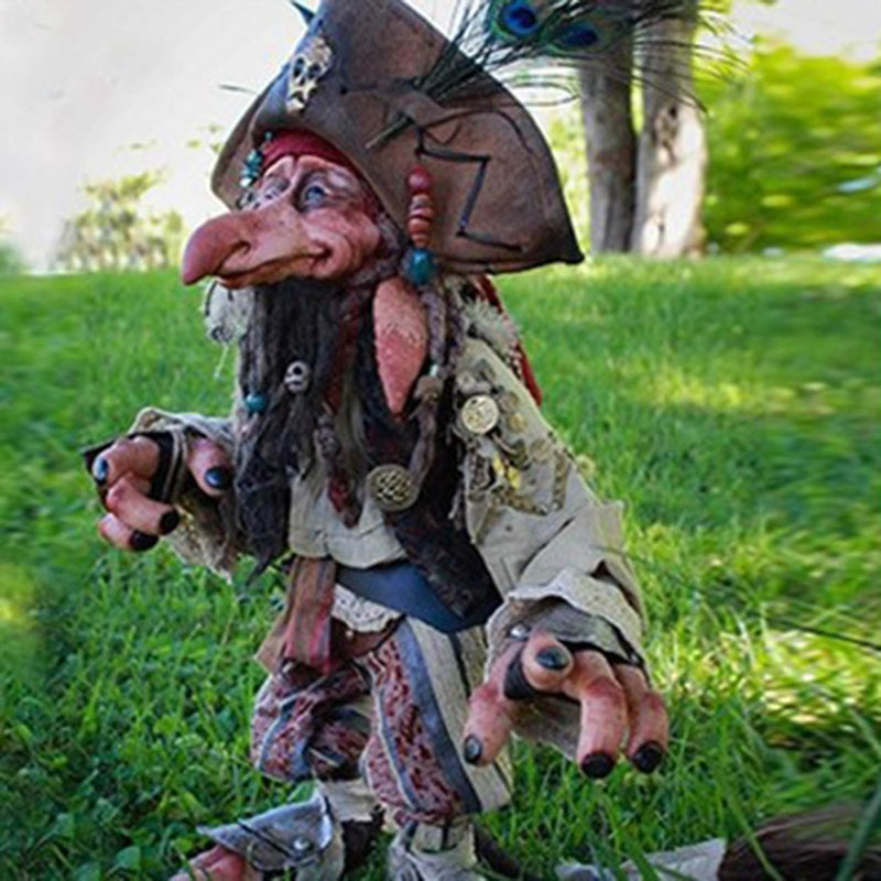 Gothic pirate goblin sculpture with tricorn hat and peacock feather standing in grass