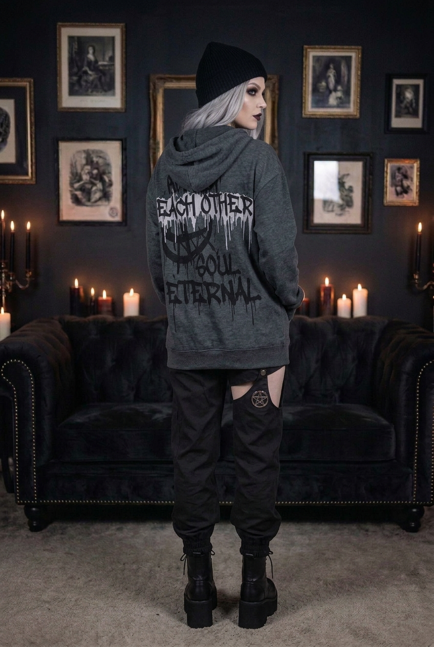 Oversized dark gray gothic hoodie with 'Each Other Soul Eternal' drip text graphic print on back, worn by goth model with black beanie and platform combat boots, back view in candlelit gothic interior — Shadow Realm Supply